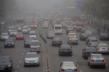 Vehicles move in the fog in Zhengzhou, capital of central China&apos;s Henan Province, Nov. 26, 2009. The city witnesses the dense fog in the past 3 days. (Xinhua/Zhu Xiang)