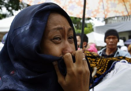 A family member weeps during a funeral in Buluan town for five members of the Mangudadatus political clan who were among those massacred in Ampatuan, Maguindanao in southern Philippines November 26, 2009. On Monday, about 100 armed men attacked a convoy carrying members of the Mangudadatus family who were on their way to file the candidacy of one of the family for the provincial governor's post in elections next year, killing 57 people.(Xinhua/Reuters Photo)