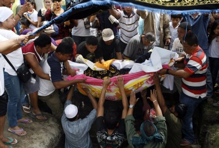 Relatives and mourners bury members in Buluan town of the Mangudadatus political clan, who was among those massacred in Ampatuan, Maguindanao, in southern Philippines November 26, 2009.(Xinhua/Reuters Photo)