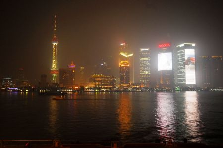 The photo taken on Nov. 25, 2009 shows the Pudong area and the Huangpu River shrouded in heavy fog in Shanghai, east China. The meteorological department of Shanghai issued the first red warning signal of fog this winter on Nov. 26. Air flights and expressway traffic were affected to some extent by the fog since Wednesday.[Xinhua]