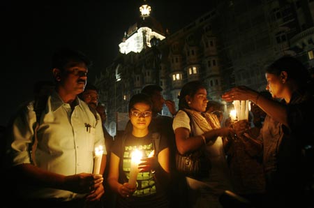 People light candles at a vigil for the victims of last year&apos;s militant attacks outside the Taj Mahal hotel in Mumbai November 25, 2009. 26 November marks the one year anniversary of the Mumbai attack.[Xinhua/Reuters]