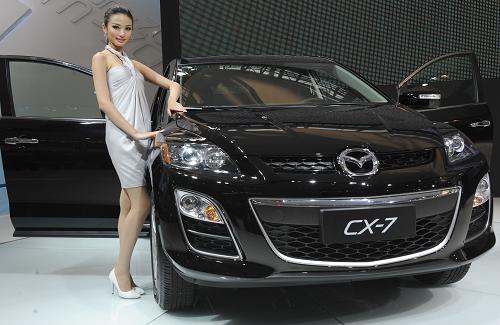 A model displays a Mazda CX-7 SUV during the 7th Guangzhou International Auto Show in Guangzhou, capital of south China&apos;s Guangdong Province, Nov. 25, 2009. [Lu Hanxin/Xinhua]