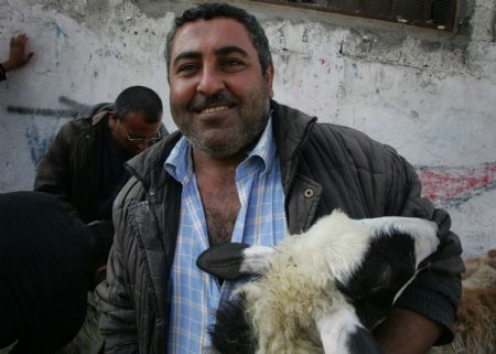 Palestinians sell sheep at a market in the middle of Gaza City, Nov. 26, 2009. Muslims around the world are preparing to celebrate Eid-al-Adha, also known as the Feast of Sacrifice, which falls on Nov. 28 this year. [Yasser Qudih/Xinhua]