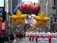 Balloons of cartoon characters pass through the Times Square during the 83rd Macy's Thanksgiving parade in New York, the U.S., Nov. 26, 2009. [Shen Hong/Xinhua]
