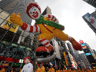 A clown balloon passes through Times Square during the 83rd Macy's Thanksgiving parade in New York, the U.S., Nov. 26, 2009. [Shen Hong/Xinhua]