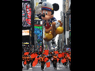 A Mickey Mouse balloon passes through Times Square during the 83rd Macy's Thanksgiving parade in New York, the U.S., Nov. 26, 2009. [Shen Hong/Xinhua] 