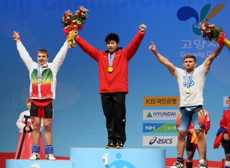 Lu Yong (C) of China poses on the podium during the awarding ceremony for the men&apos;s 85kg category at the World Weightlifting Championships in Goyang, north of Seoul, South Korea, Nov. 26, 2009. Lu Yong won the gold medal with 383kg. [He Lulu/Xinhua] 