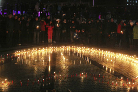 People pray for the dead miners of a coal mine accident at the Zhenxing Square in Hegang City, northeast China&apos;s Heilongjiang Province, Nov. 25, 2009. Hundreds of people gathered at the square to mourn for the miners dead in the accident occurring in the Xinxing Coal Mine on Nov. 21. An explosion in the mine caused 92 miners dead and 16 others still missing. [Bai Changhai/Xinhua]