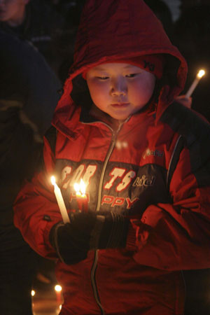 A child prays for the dead miners of a coal mine accident at the Zhenxing Square in Hegang City, northeast China&apos;s Heilongjiang Province, Nov. 25, 2009. Hundreds of people gathered at the square to mourn for the miners dead in the accident occurring in the Xinxing Coal Mine on Nov. 21. An explosion in the mine caused 92 miners dead and 16 others still missing. [Bai Changhai/Xinhua]