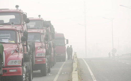 Trucks are stranded due to heavy fog in Jinan, East China's Shandong province, November 25, 2009.[CFP]