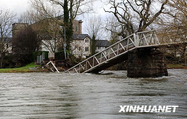 A bridge destroyed by flood is seen in Cockermouth, northwest England, Nov. 26, 2009. The British Environment Agency has announced that only one flood warning remains in force in Cumbria, a week after unprecedented rainfall prompted some of the country&apos;s worst ever flooding, while Cumbria County Council has said that 21 road bridges are still closed. [Zeng Yi/Xinhua]