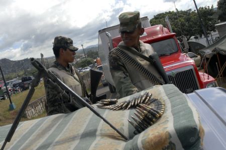 Policemen guard the van loaded with the documents for the upcoming general election in Tegucigalpa, capital of Honduras, on Nov. 26, 2009. The election is scheduled on Nov. 27, 2009. [Rafael Ochoa/Xinhua]