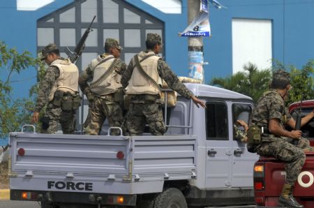 Policemen guard the van loaded with the documents for the upcoming general election in Tegucigalpa, capital of Honduras, on Nov. 26, 2009. The election is scheduled on Nov. 27, 2009. [Rafael Ochoa/Xinhua] 