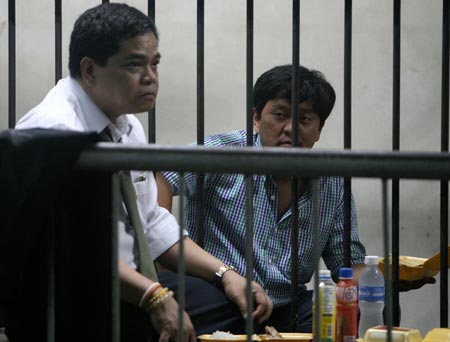 Maguindanao Massacre suspect Andal Ampatuan Jr. (R) speaks with his lawyer in detention in a National Bureau of Investigation cell in Manila, capital of Philippines, Nov. 26, 2009. (Xinhua Photo)