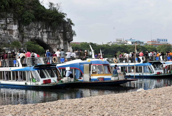 Tourists view the scenery of the Elephant Trunk Hills on crowded boats berthed on the narrow Lijiang River. Nov. 8, 2009. [Chen Ruihua/Xinhua] 