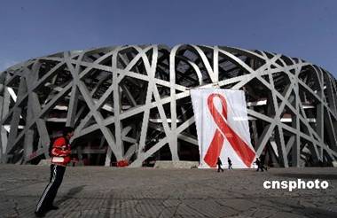 A poster of red ribbon, the symbol of care for AIDS patients, standing in front of Beijing National Stadium on December 1, 2008, World AIDS Day [chinanews.com.cn]