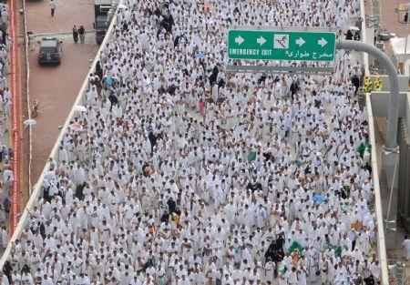 Muslim pilgrims move to take part in an exorcising ceremony to throw detritus to stone walls which symbolize the devil, during the annual hajj pilgrimage in Mecca, Saudi Arabia, Nov. 27, 2009.