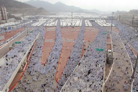 Muslim pilgrims move to take part in an exorcising ceremony to throw detritus to stone walls which symbolize the devil, during the annual hajj pilgrimage in Mecca, Saudi Arabia, Nov. 27, 2009.