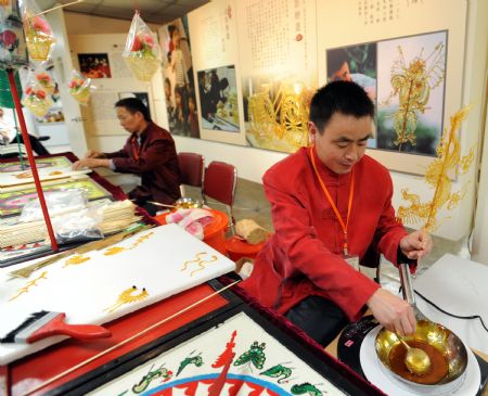 Xie Fengkun from southwest China's Chengdu City performs the making of sugar sculpture at the Chinese Intangible Cultural Heritage Show held in Taipei, Taiwan, Nov. 27, 2009.