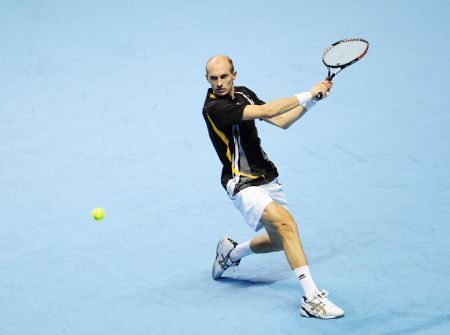 Nikolay Davydenko of Russia returns the ball during the ATP World Tour Finals Group B Singles third round match against Robin Soderling of Sweden in London, capital of Britain, Nov. 27, 2009. Davydenko won 2-1.