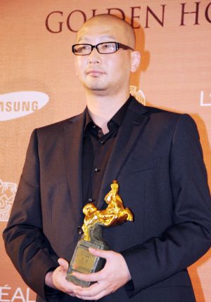 Chinese director Guan Hu poses with the best screenplay adaption award for 