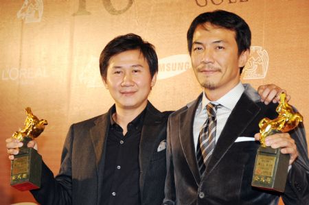 Director Leon Dai (R) and actor Chen Wen-pin hold trophies after winning the Best Original Screenplay awards for the film 