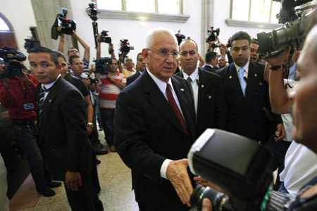 Honduras' de facto leader Roberto Micheletti greets a journalist during a mass in Tegucigalpa November 23, 2009. (Xinhua/Reuters File Photo)