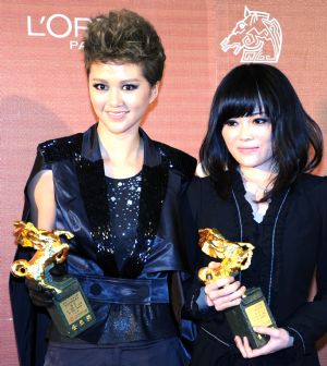 Chinese singer Tan Weiwei (L) and Chinese composer Zeng Yan hold the awards for Best Original Song for the film 