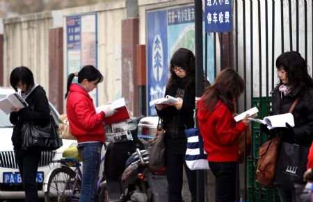 Examinees review their materials before the examination starts in Shanghai, east China, Nov. 29, 2009. The annual examination for selecting national public servants was held in main cities of China Sunday. (Xinhua/Liu Ying) 