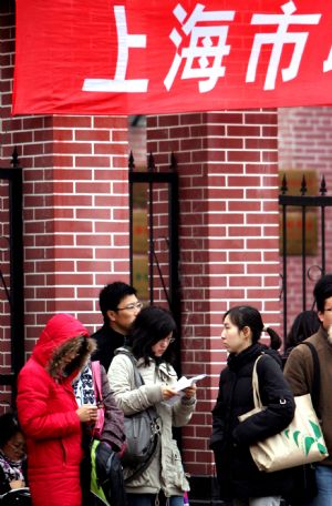 Examinees wait before the examination starts in Shanghai, east China, Nov. 29, 2009. The annual examination for selecting national public servants was held in main cities of China Sunday. (Xinhua/Liu Ying)