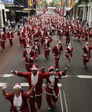 About 1,800 people dressed in Santa costumes run down the main street in central Sydney November 29, 2009. Organisers of the Variety Club Santa Fun Run, in support of a children&apos;s charity, aim to build on Sunday&apos;s event and challenge the world record for people running dressed as Santa.