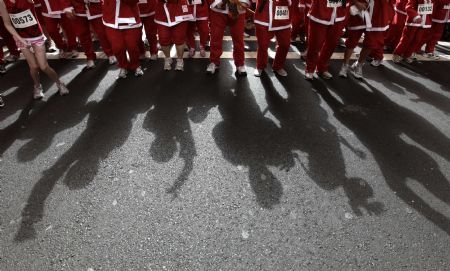 About 1,800 people dressed in Santa costumes walk down the main street in central Sydney November 29, 2009. Organisers of the Variety Club Santa Fun Run, in support of a children&apos;s charity, aim to build on Sunday&apos;s event and challenge the world record for people running dressed as Santa. 