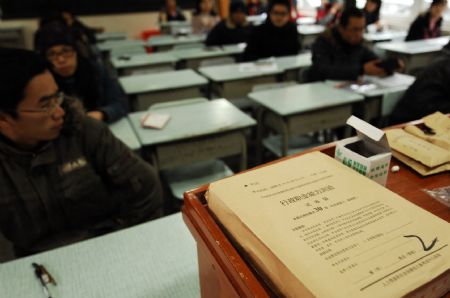 Examinees waits in a classroom before the examination starts in Nanchang, capital of east China's Jiangxi Province, Nov. 29, 2009. The annual examination for selecting national public servants was held in main cities of China Sunday. (Xinhua/Zhou Mi) 