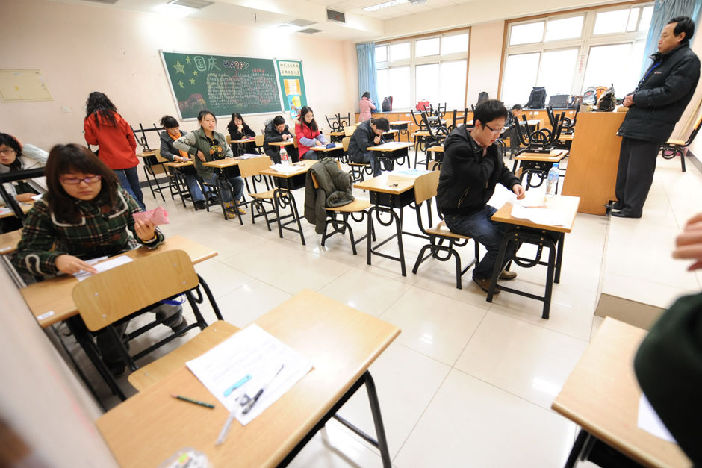Examinees waits in a classroom before the servant recruitment exam starts at Beijing No. 171 High School, Nov. 29. Almost 1 million people Sunday sat China&apos;s national examination for 2010 admissions to the civil service. [Xinhua]