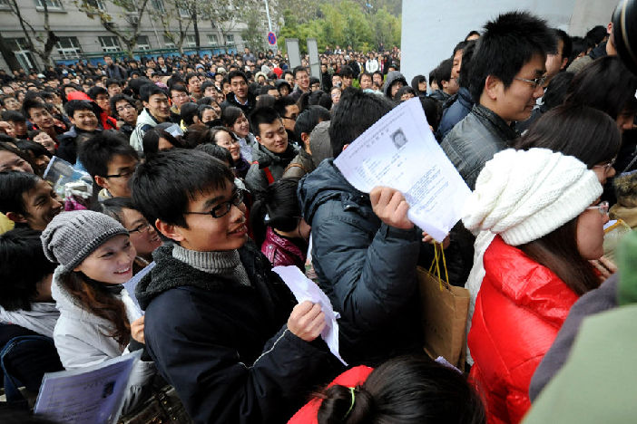 Examinees wait before the servant recruitment exam starts in Nanjing, East China&apos;s Jiangsu Province, Nov, 29, 2009. Almost 1 million people Sunday sat China&apos;s national examination for 2010 admissions to the civil service. [Xinhua]