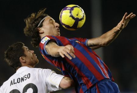 Barcelona's Zlatan Ibrahimovic (R) and Real Madrid's Xabi Alonso fight for the ball during their Spanish first division soccer match at Camp Nou stadium in Barcelona November 29, 2009.  (Xinhua/Reuters Photo) 