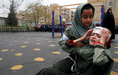 Students of a middle school attend a earthquake drill in Tehran, capital of Iran, Nov. 29, 2009. (Xinhua/Ahmad Halabisaz)