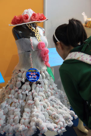 A girl visitor admires a suit of wedding dress made of plastic package at the 4th Bejing Cultural and Creative Fair in Beijng, the capital city of China on Nov. 28, 2009. The fair, which was kicked off on Saturday, exhibited various strange and interesting cultural creations and attracted a great number of visitors.