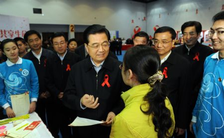 Chinese President Hu Jintao (C) talks with a volunteer from a medical university while taking part in a gathering of AIDS prevention volunteers in Beijing, capital of China, Nov. 30, 2009, a day before the 22nd World AIDS Day. Chinese Vice Premier Li Keqiang (3rd, R) also attended the gathering. (Xinhua/Ma Zhancheng) 