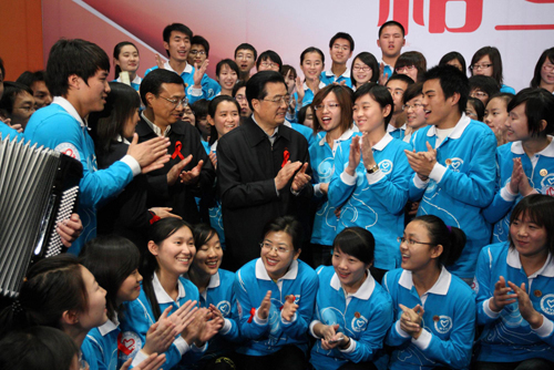 President Hu Jintao meets AIDS prevention volunteers during a gathering at the China National Convention Center in Beijing, a day before the 22nd World AIDS Day. The president pledged to mobilize the whole society to improve HIV/AIDS control. [Xinhua