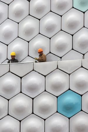 Workers proceed on the building site of Information and Communications pavilion of the 2010 Shanghai World Expo in Shanghai, east China, Nov. 29, 2009. Most of the pavilions are taking on a dashing look with the coming of the 2010 Shanghai World Expo, which will fall in May of next year. 