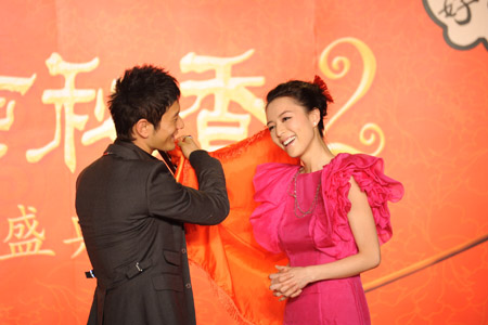 Leading cast staff and protagonist Huang Xiaoming unveils the headscarf for Zhang Jingchu during a high-profile shooting inception ceremony of the new film Flirting Scholar: Tang Bohu Woos Qiuxiang II, an traditional romantic comedy that enjoys great popularity among Chinese folklore, in Beijing, Nov. 30, 2009. (Xinhua)