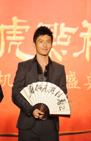 Leading cast staff and protagonists Huang Xiaoming strikes posture during a high-profile shooting inception ceremony of the new film Flirting Scholar: Tang Bohu Woos Qiuxiang II, an traditional romantic comedy that enjoys great popularity among Chinese folklore, in Beijing, Nov. 30, 2009. (Xinhua)