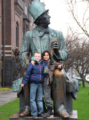 Photo taken on Nov. 22, 2009 shows children posing for a photo with the statue of Danish author Hans Christian Andersen in Copenhagen, capital of Denmark. (Xinhua/Zhao Changchun)