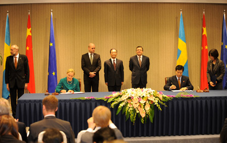 Chinese Premier Wen Jiabao (C), European Commission President Jose Manuel Barroso (3rd R, back) and Swedish Prime Minister Fredrik Reinfeldt (3rd L, back), whose country currently holds the rotating EU presidency, attend the signing ceremony of five cooperative documents after the 12th China-EU summit in Nanjing, capital of east China's Jiangsu Province, Nov. 30, 2009. [Han Yuqing/Xinhua]