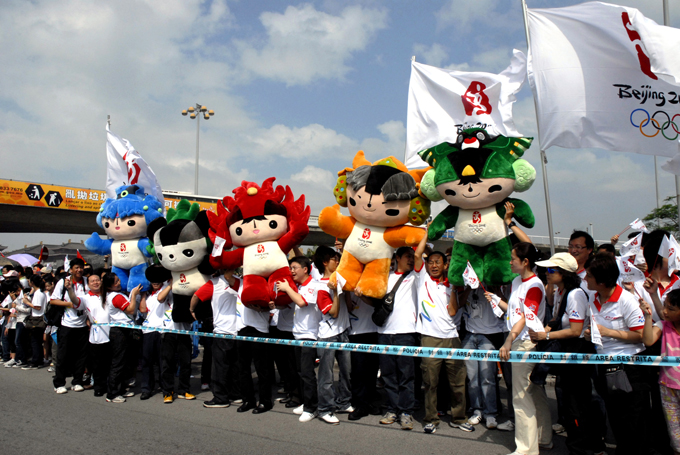 People in Macao hold the Beijing Olympic mascot to welcome Olympic flame's arriving.