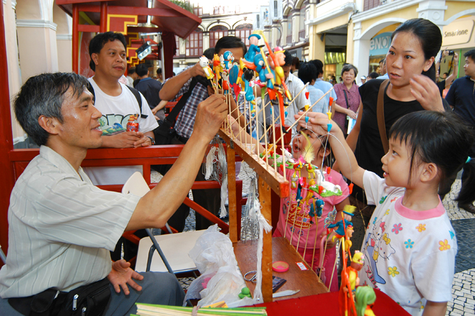 Children gaze at folk artwork by an artist from China's mainland at Senado Square. Macao built a tight relationship with China after it was returned to the PRC. 