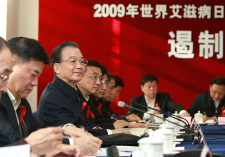 Chinese Premier Wen Jiabao (3rd L) and Vice Premier Li Keqiang (4th L) listen to HIV researchers' speech during their visit at the Beijing Home of Red Ribbon in Ditan Hospital in Beijing, capital of China, Dec. 1, 2009. (Xinhua/Pang Xinglei)