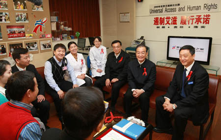 Chinese Premier Wen Jiabao (2nd R, rear) and Vice Premier Li Keqiang (3rd R, rear) talk with AIDS patients and medical volunteers, experts at the Beijing Home of Red Ribbon in Ditan Hospital in Beijing, capital of China, Dec. 1, 2009. (Xinhua/Pang Xinglei)