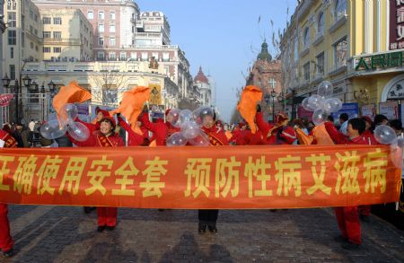 Volunteers carrying a large poster urging for a concerted effort to battle AIDS promote for AIDS prevention in Harbin, capital of northeast China&apos;s Heilongjiang Province, Dec. 1, 2009, World AIDS Day. (Xinhua/Wang Song)